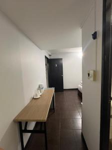 a small room with a wooden table and a hallway at Maland House Hostel - Pattaya soi 14 Saisong Road in Pattaya South