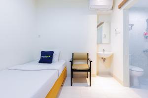 Postel nebo postele na pokoji v ubytování Urbanview Hotel Mitra near Grand Indonesia