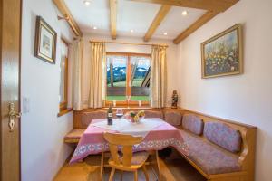 a dining room with a table and a couch at Haus Aigner in Fischen