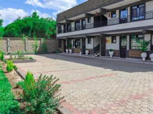a large building with a brick driveway in front of it at Jay Homes - Weber Generations Accommodations in Naivasha
