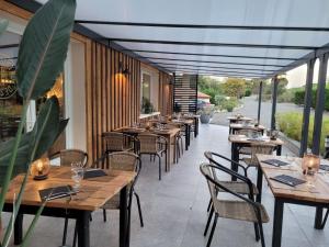 a row of tables and chairs at a restaurant at Hôtel LES LODGES D'EAUZE in Eauze