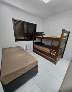 Un dormitorio con dos literas y una ventana. en Pitangueiras 1 , 2 dormitórios, piscina climatizada, 100 m praia, duas vagas de garagem e Wi-Fi, en Guarujá