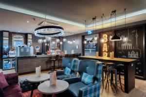 a bar in a restaurant with blue chairs and a counter at Premier Inn Berlin City Süd in Berlin +34 photos