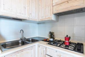 una cocina con fregadero y estufa en Sandy Bear Guesthouse - Happy Rentals, en Palau