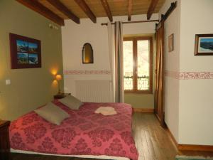 a bedroom with a bed with a red blanket at Chambre d'Hotes La Mexicaine in Jausiers