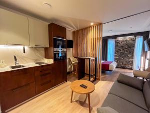 a kitchen and a living room with a couch and a table at La Quinta del Sordo in Luarca