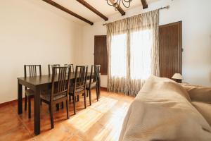 a dining room with a table and chairs and a couch at Casa Higuera de la Sierra in Higuera de la Sierra