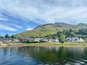 a village on the shore of a body of water at Glas Eilean View, Dornie in Dornie