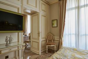 a bedroom with a bed and a tv and a chair at Maison des Barons in Nice