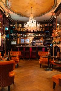a bar with chairs and a chandelier at The Pavilions Amsterdam, The Toren in Amsterdam