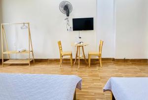 a room with two beds and a table and chairs at Hà Linh Motel in Vung Tau