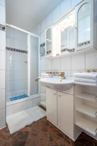 biała łazienka z umywalką i prysznicem w obiekcie Dietrich Comfort Appartements w mieście Telfs
