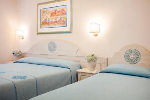 Postel nebo postele na pokoji v ubytování HOTIDAY Room Collection - Baja Sardinia
