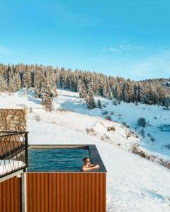 弗拉西克Euphoria - luxury villa的下雪时在热水浴池里的人