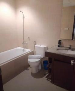 a bathroom with a toilet and a tub and a sink at Ex Hotel Aston Marina Ancol in Jakarta