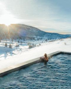 弗拉西克Euphoria - luxury villa的雪覆盖的田野里,在热水浴池中的女人