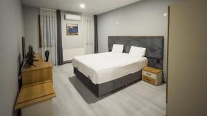 a bedroom with a large white bed in a room at Altınova Hotel Sakarya in Serdivan
