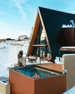 弗拉西克Euphoria - luxury villa的一名女子在建筑物的游泳池里