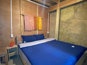 a bedroom with a blue bed in a room at Lullaby Ha Giang Homestay in Loung Co