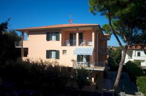 un immeuble d'appartements avec un balcon et un arbre dans l'établissement Residence Loggetta Margherita, à San Vincenzo