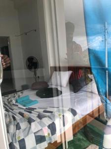 a bedroom with a bed with a reflection of a boy at NV Homestay in Ella
