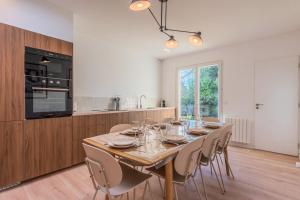 a dining room with a wooden table and chairs at Maison 3 chambres et 2 salle de bain avec jardin in Tourcoing