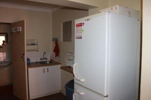 a kitchen with a white refrigerator and a sink at Holiday Villa Diaz Beach Mossel Bay in Mossel Bay