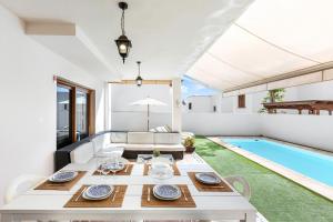 a living room with a table and a swimming pool at Casahost Aquavilla in Costa Teguise