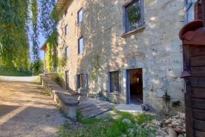 an old stone building with a wooden walkway outside at Gites du Longevent Appartement du Moulin Pérouges in Meximieux