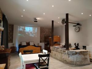 a living room with a stone fireplace and a bedroom at Gites du Longevent Appartement du Moulin Pérouges in Meximieux