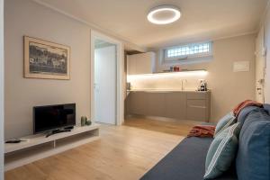 un soggiorno con divano e TV e una cucina di Alfieri Apartment a Firenze