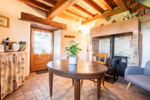 a living room with a table and a wood stove at La Petite Tour du Château de Salornay in Hurigny
