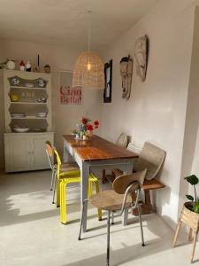 a dining room with a table and yellow chairs at Trullo KAVA - Ceglie Messapica in Ceglie Messapica