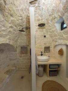 a bathroom with a sink and a stone wall at Trullo KAVA - Ceglie Messapica in Ceglie Messapica +32 photos