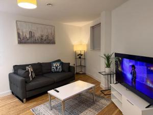 a living room with a couch and a flat screen tv at Manchester waterside Haven in Manchester