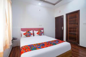 Rúm í herbergi á FabHotel HSR Gateway
