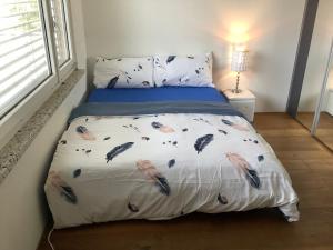 un letto con piume sopra la camera da letto di Chambre spacieuse, lumineuse et reposante a Oetwil an der Limmat