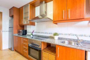 kuchnia z drewnianymi szafkami i zlewem w obiekcie Altorreal - Más que apartamentos w Murcji +14 zdjęć