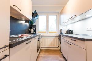 eine Küche mit weißen Schränken und einem Fenster in der Unterkunft Am Hof 4 in Staberdorf