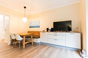 ein Esszimmer mit Tisch und Fernseher in der Unterkunft Am Hof 4 in Staberdorf