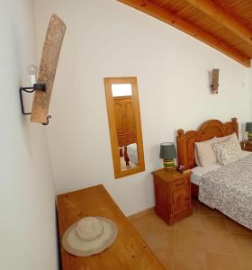 a bedroom with a bed and a table and a mirror at Casa Roma in Raposeira