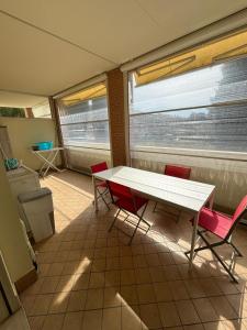 Una mesa y sillas en una habitación con ventana. en Casa Nonna Grazia, en Pedaso