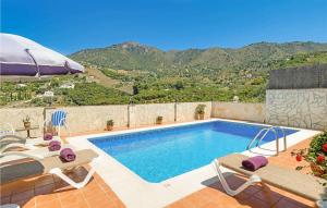 a swimming pool with two chairs and an umbrella at Casa La Era in Frigiliana