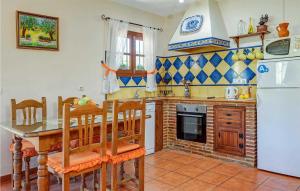a kitchen with a table and a white refrigerator at Casa La Era in Frigiliana