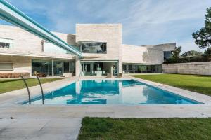 a swimming pool in front of a house at Encinas4 - Villa de lujo by A-Cero Living in Pozuelo de Alarcón