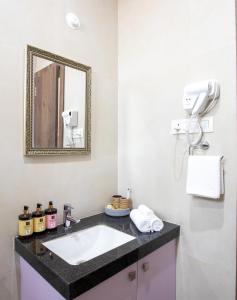 un bagno con lavandino e specchio di ELIVAAS Heaven in Hills Valora 6 BHK Pet friendly villa with Pvt Pool a Udaipur
