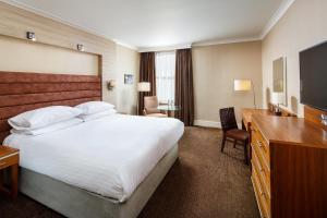 a hotel room with a large bed and a desk at Cheltenham Chase Hotel & Spa in Cheltenham