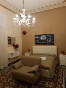 Un dormitorio con una cama y una lámpara de araña. en DayBreak B&B, en Palermo