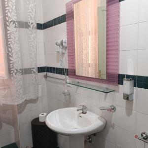 un baño con lavabo y espejo en DayBreak B&B, en Palermo