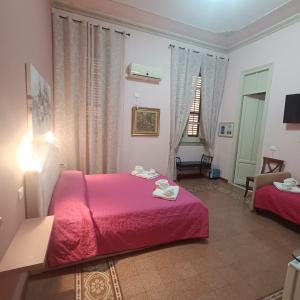 Un dormitorio con dos camas con sábanas rojas y una ventana. en DayBreak B&B, en Palermo